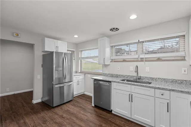 a kitchen with a refrigerator sink and cabinets