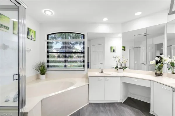 a bathroom with a bathtub sink and mirror