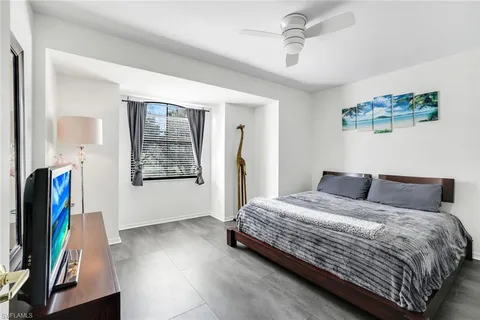 a bedroom with a bed and a flat tv screen on a dresser