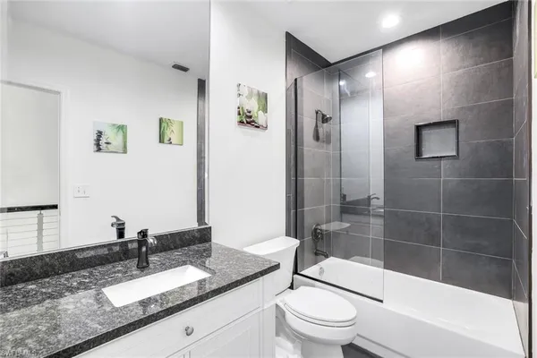 a bathroom with a granite countertop sink toilet and shower