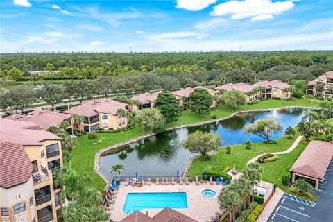 an aerial view of residential houses with outdoor space and lake view