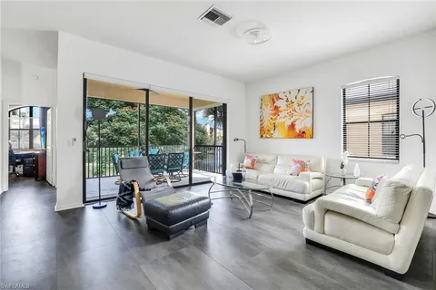a living room with furniture and floor to ceiling windows