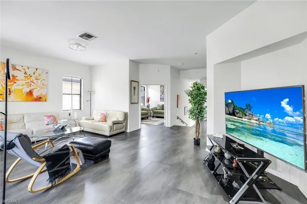 a living room with furniture a dining table and a potted plant