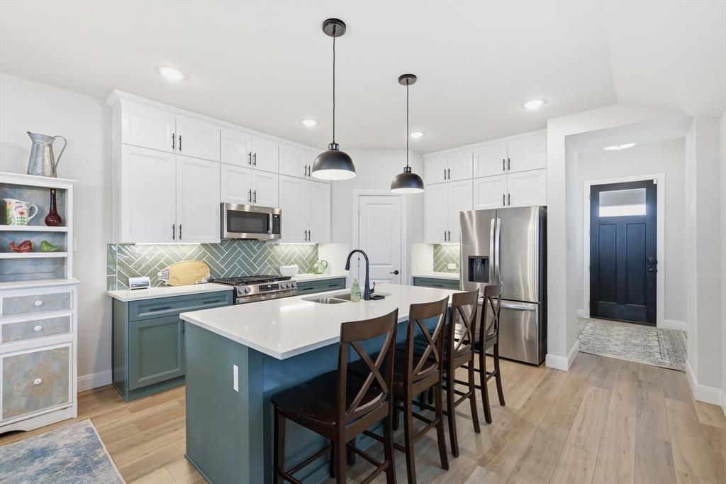 1018 Abigail Way Midlothian, TX 76065 - Photo 11 of 26 a kitchen with stainless steel appliances a dining table chairs stove and refrigerator