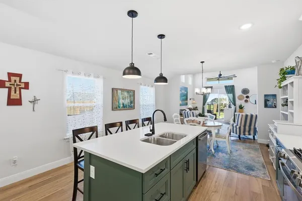 a kitchen with granite countertop a sink a counter space appliances and cabinets
