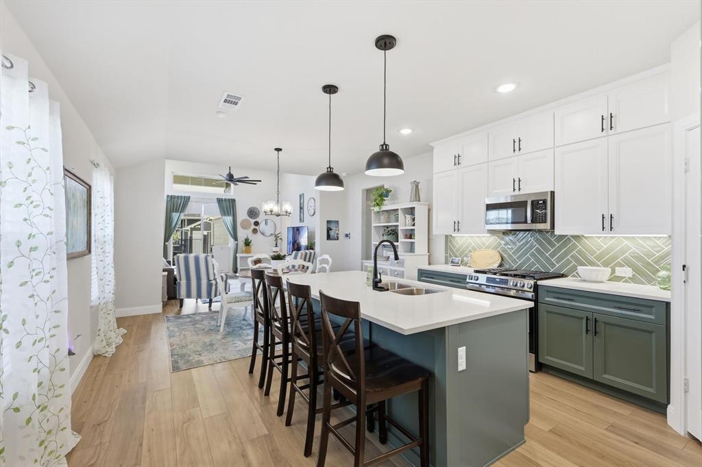 1018 Abigail Way Midlothian, TX 76065 - Photo 2 of 26 a kitchen with stainless steel appliances kitchen island granite countertop a sink a stove a dining table and chairs