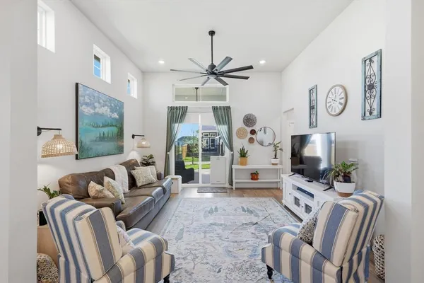a living room with furniture a flat screen tv and a chandelier