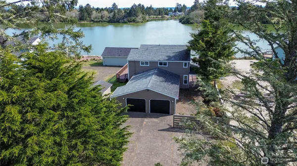 an aerial view of a house with a yard and a large tree