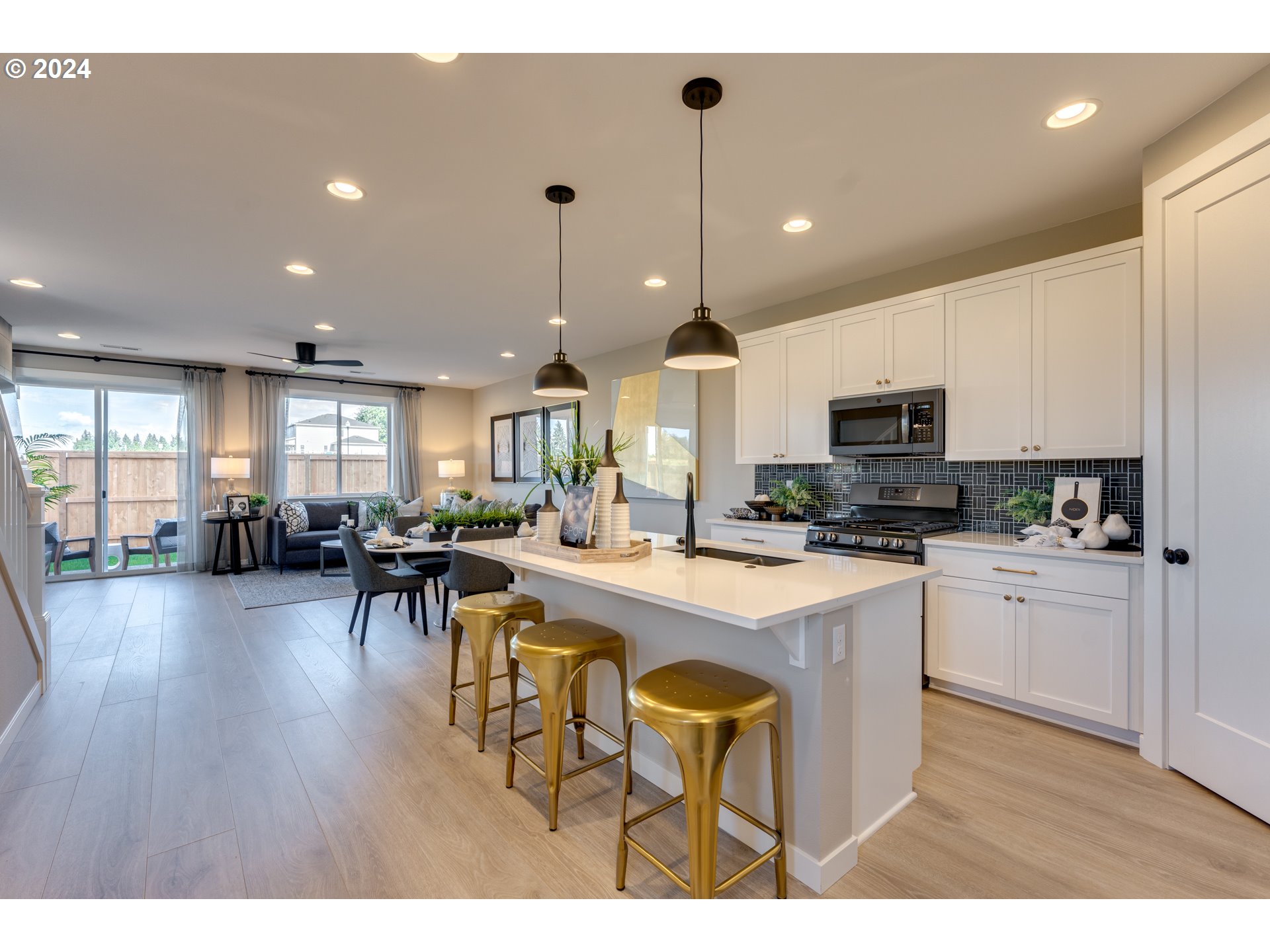 842 Northwest 178th Street Ridgefield, WA 98642 - Photo 32 of 46 a kitchen with stainless steel appliances granite countertop a stove a refrigerator a kitchen island a dining table and chairs with wooden floor
