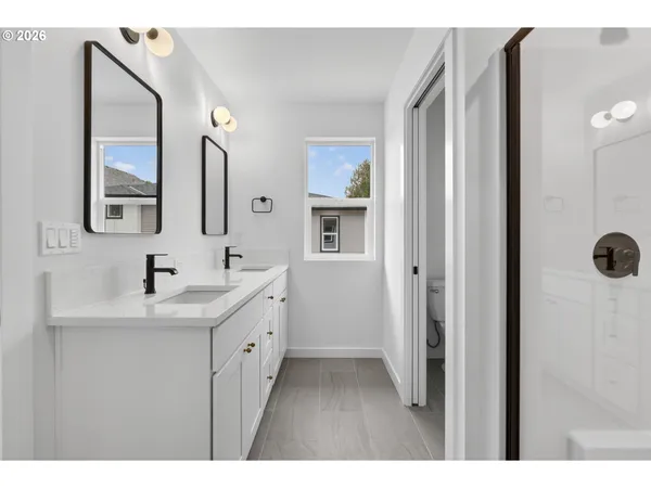 a bathroom with double vanity sinks and a mirror