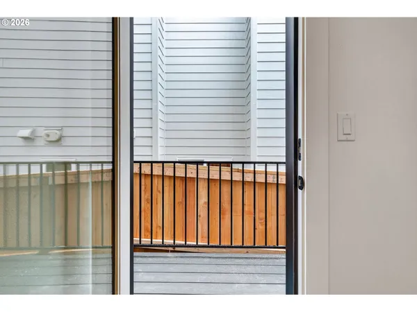 a view of kitchen with refrigerator and white cabinets