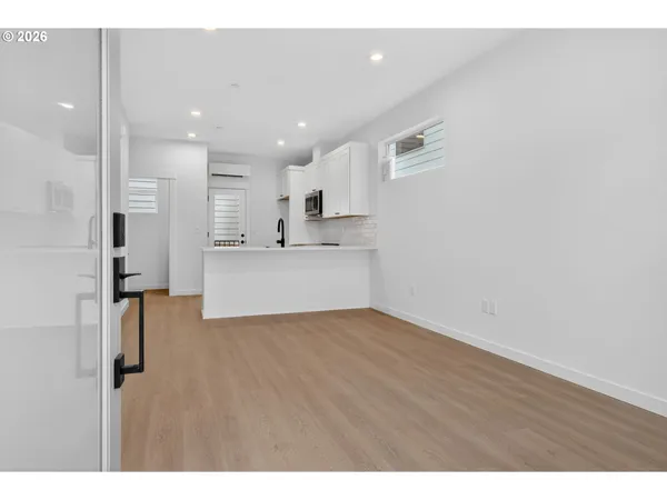 a view of a kitchen with kitchen island white wooden cabinets and refrigerator