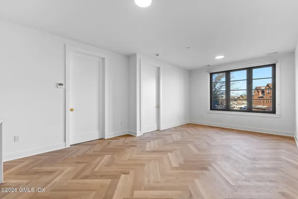 an empty room with wooden floor and windows