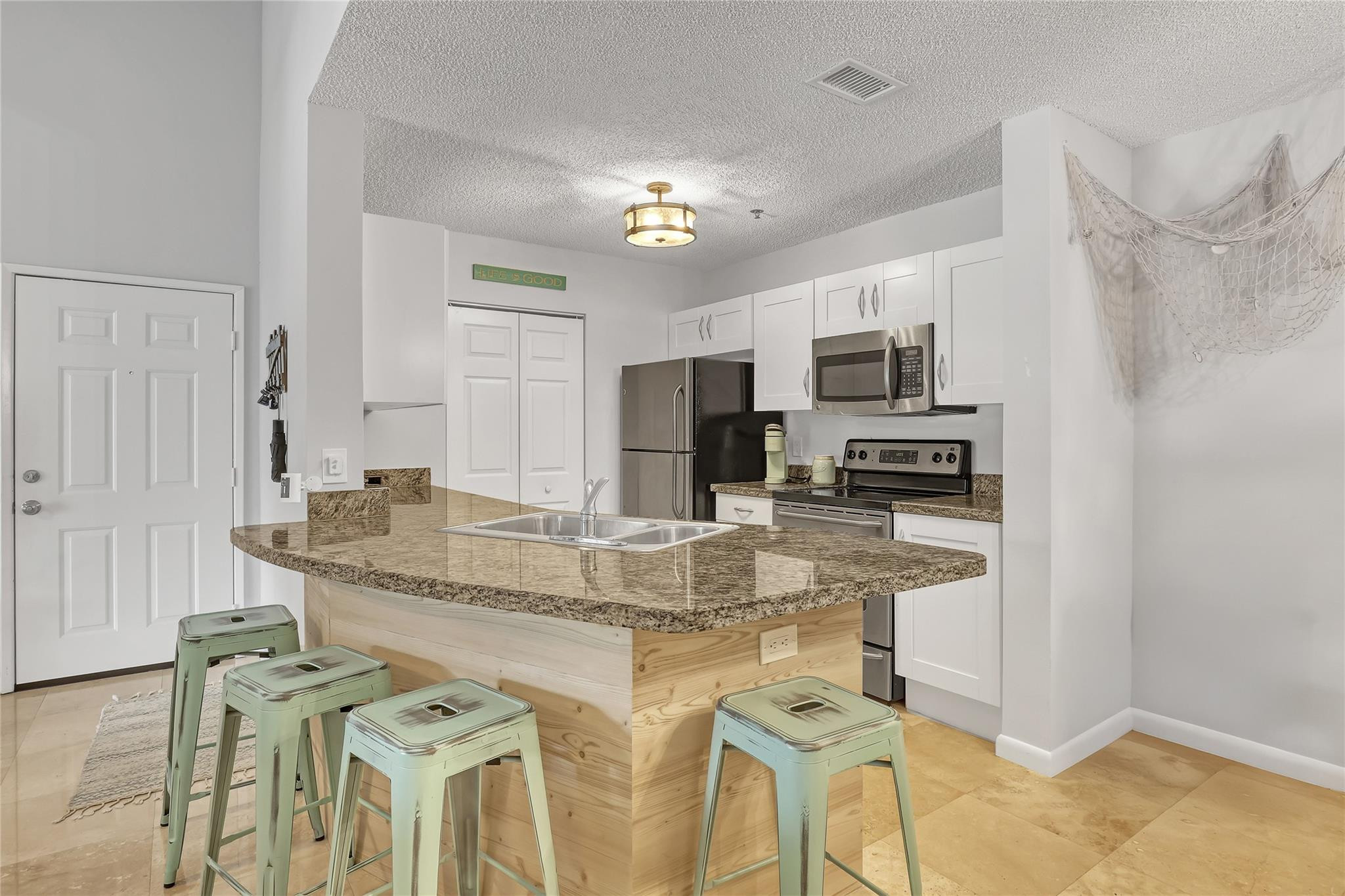 3143 Clint Moore Road, Unit 205 Boca Raton, FL 33496 - Photo 6 of 27 a kitchen with stainless steel appliances granite countertop a sink refrigerator and microwave