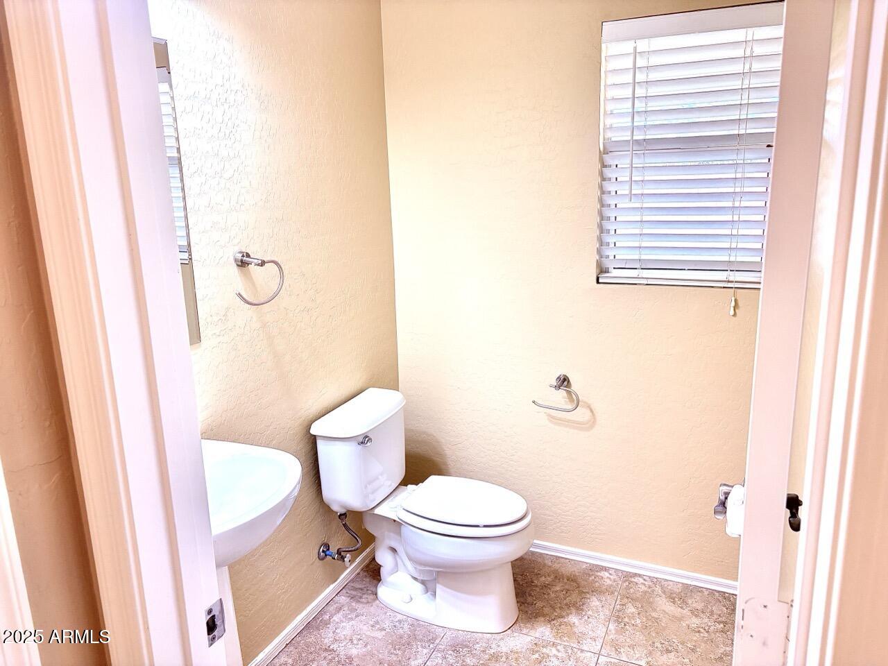 4014 East Superior Road San Tan Valley, AZ 85143 - Photo 16 of 36 a white toilet sitting next to a small sink