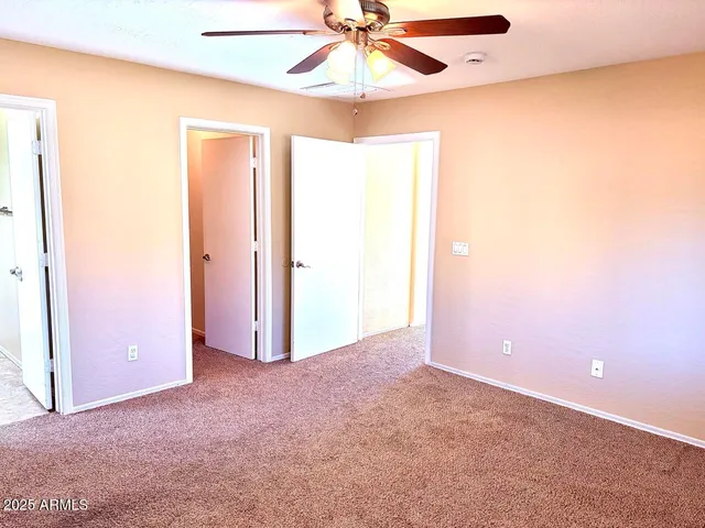 an empty room with a ceiling fan and a window