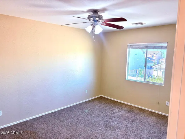 a view of a room with a ceiling fan and a window
