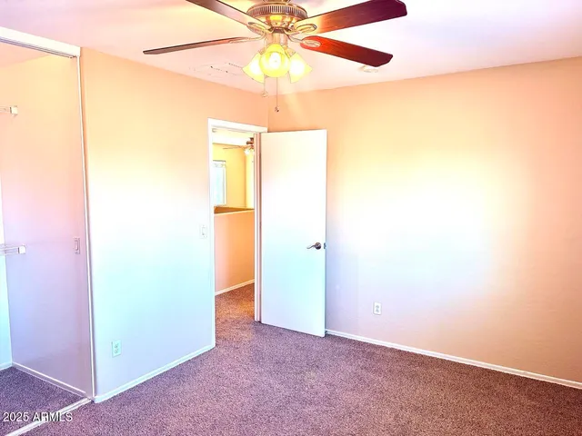 an empty room with a fan and a fan