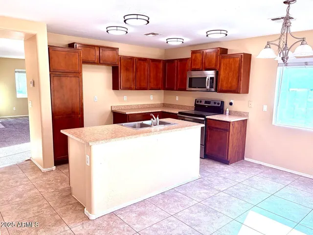 a kitchen with stainless steel appliances granite countertop a stove a sink and a refrigerator