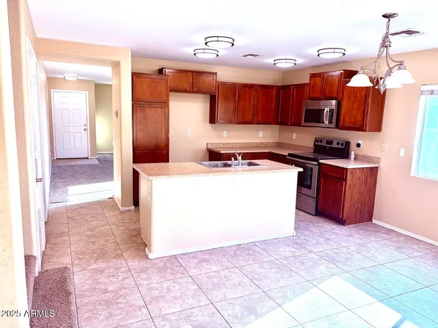 a kitchen with stainless steel appliances granite countertop a stove a sink dishwasher and a refrigerator