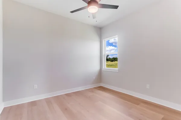 an empty room with a window and a fan