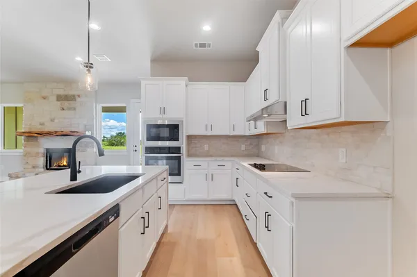 a kitchen with white cabinets and a sink
