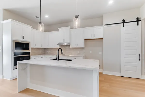 a kitchen with kitchen island a sink stainless steel appliances and cabinets