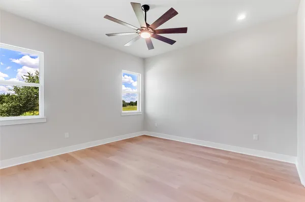 an empty room with a window and a fan
