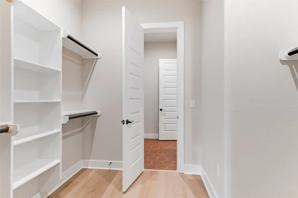 a view of walk in closet with empty racks