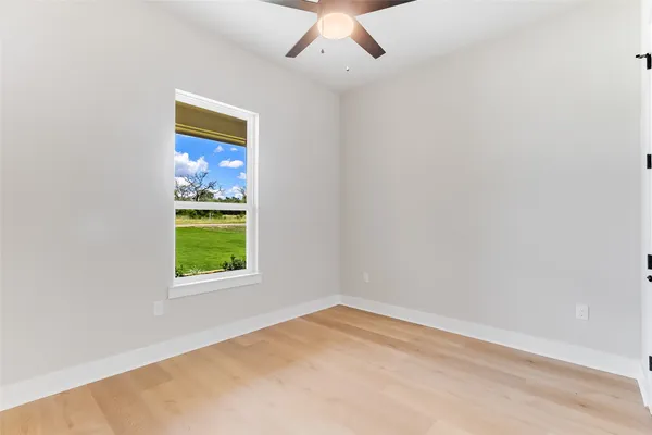 an empty room with a window and a ceiling fan