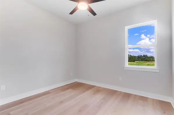 an empty room with wooden floor and window