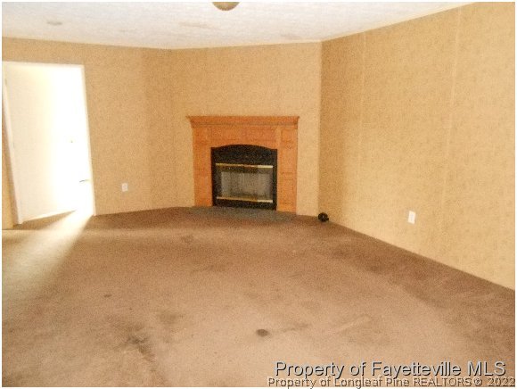 1591 Loop Road Raeford, NC 28376 - Photo 6 of 10 a view of an empty room with a fireplace