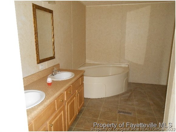 1591 Loop Road Raeford, NC 28376 - Photo 10 of 10 a bathroom with a granite countertop sink and a mirror