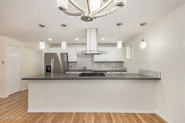 a large kitchen with stainless steel appliances kitchen island a chandelier