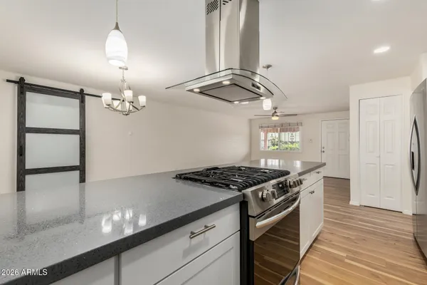 a kitchen with granite countertop a stove and a wooden floor
