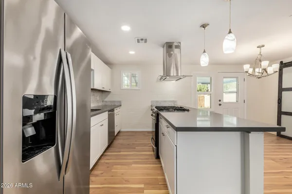 a kitchen with stainless steel appliances granite countertop a sink a stove and a refrigerator