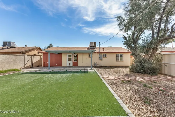 a view of a house with a yard and large tree