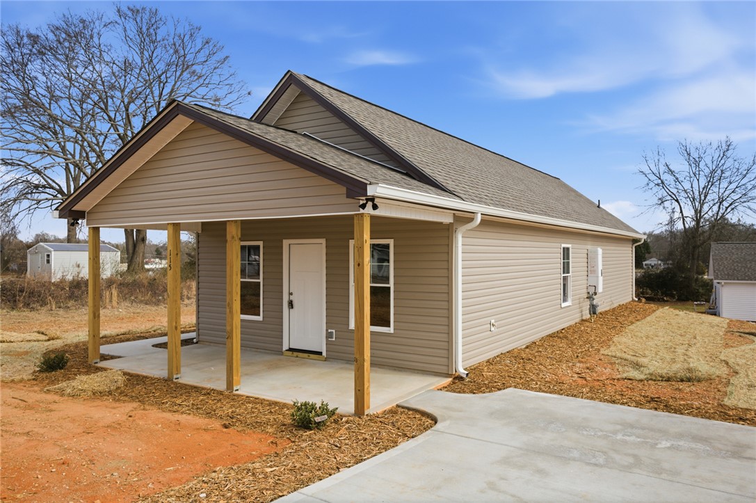 A concrete walkway leads directly to the covered front porch of this home.