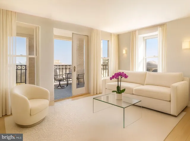 a living room with furniture and floor to ceiling windows