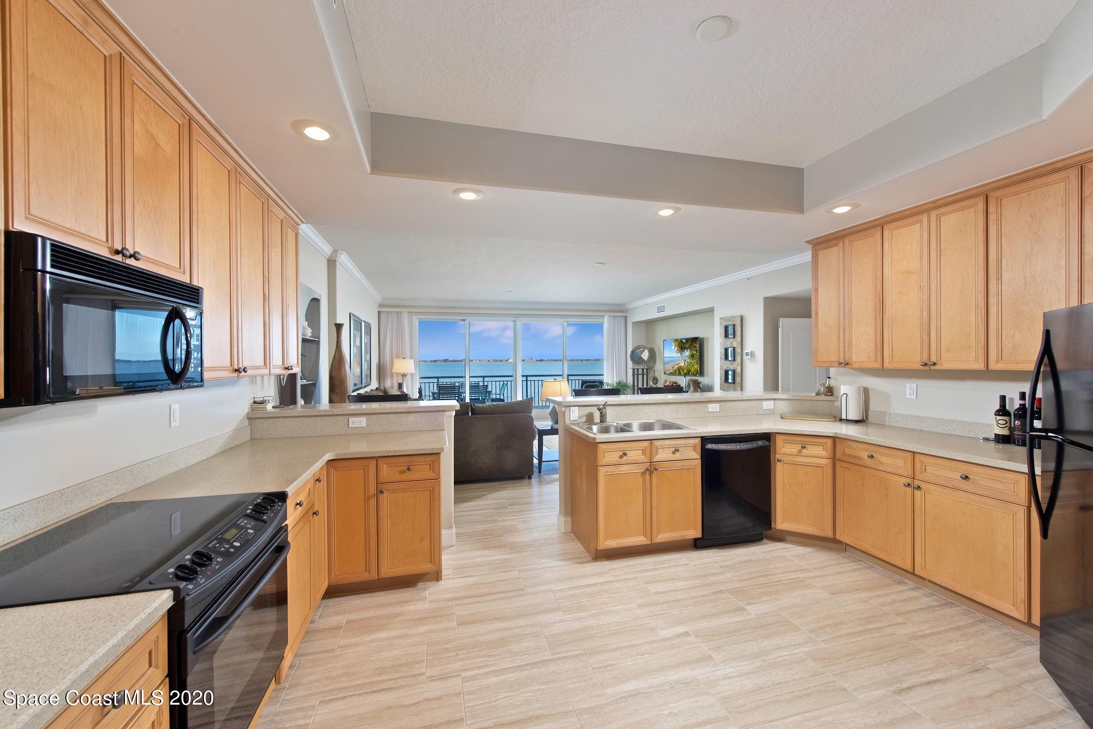 4955 Dixie Highway Northeast, Unit 404 Palm Bay, FL 32905 - Photo 12 of 50 a large kitchen with cabinets wooden floor and stainless steel appliances