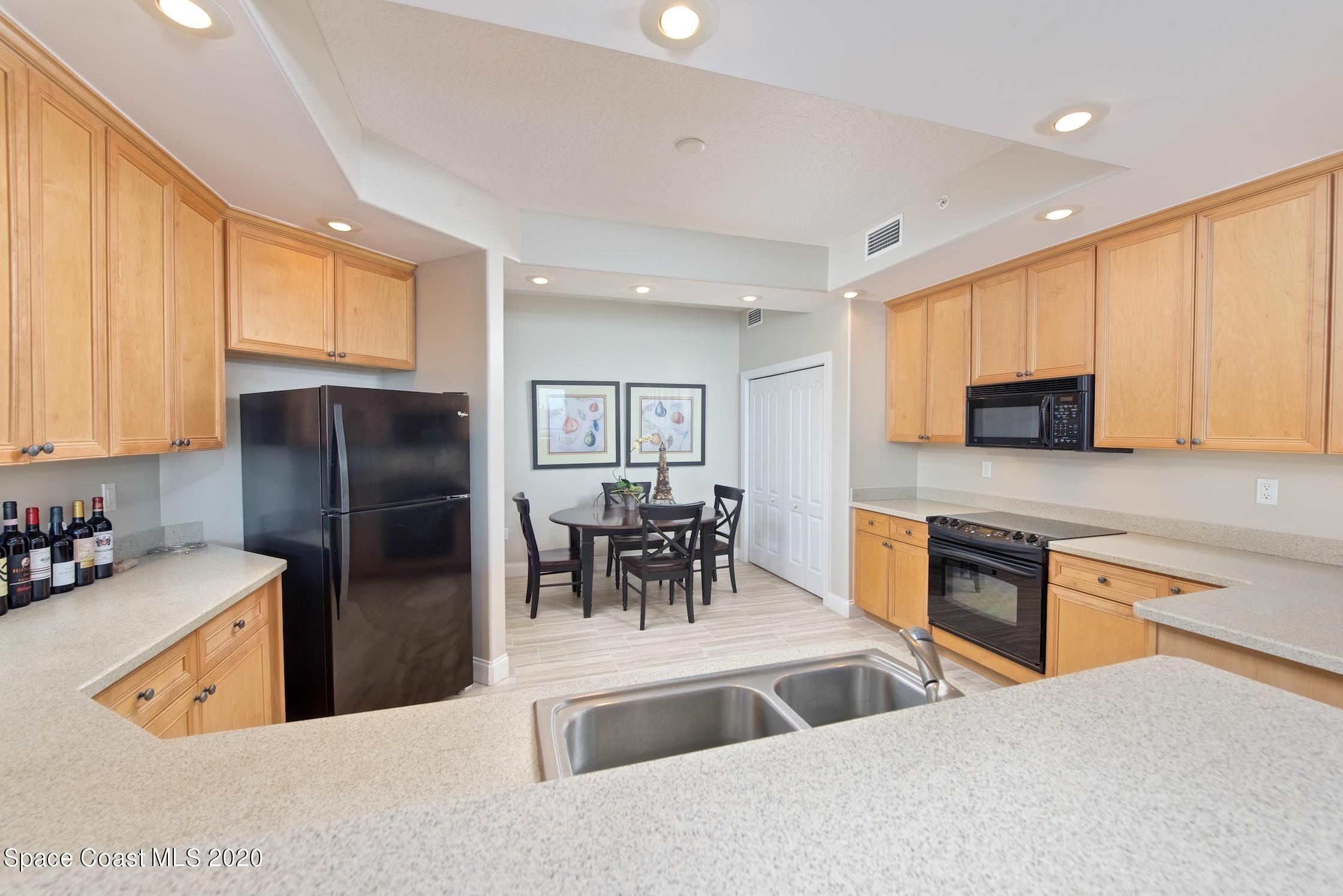 4955 Dixie Highway Northeast, Unit 404 Palm Bay, FL 32905 - Photo 13 of 50 a kitchen with stainless steel appliances granite countertop a refrigerator a stove top oven a sink and dishwasher