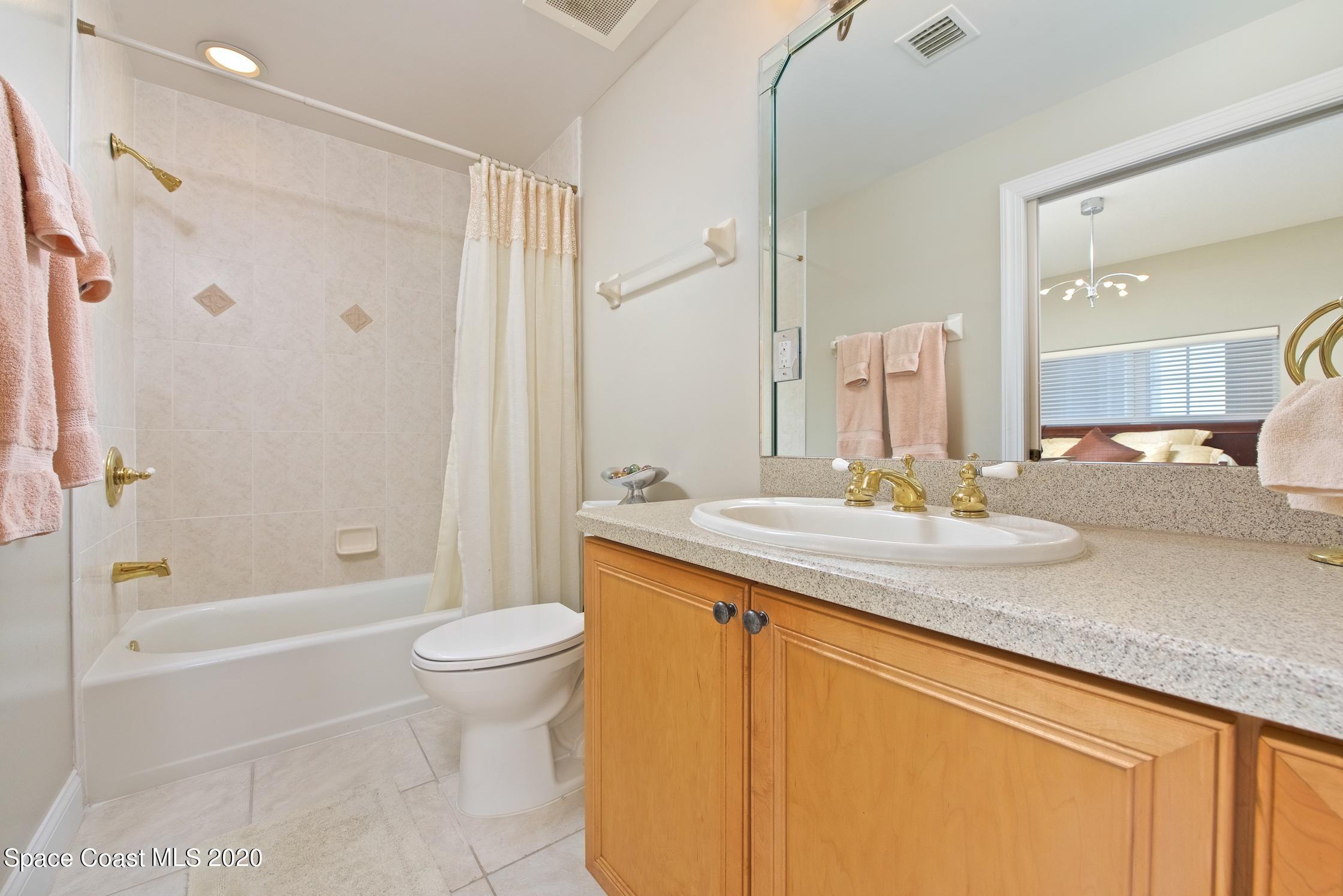 4955 Dixie Highway Northeast, Unit 404 Palm Bay, FL 32905 - Photo 21 of 50 a bathroom with a granite countertop sink a toilet and shower