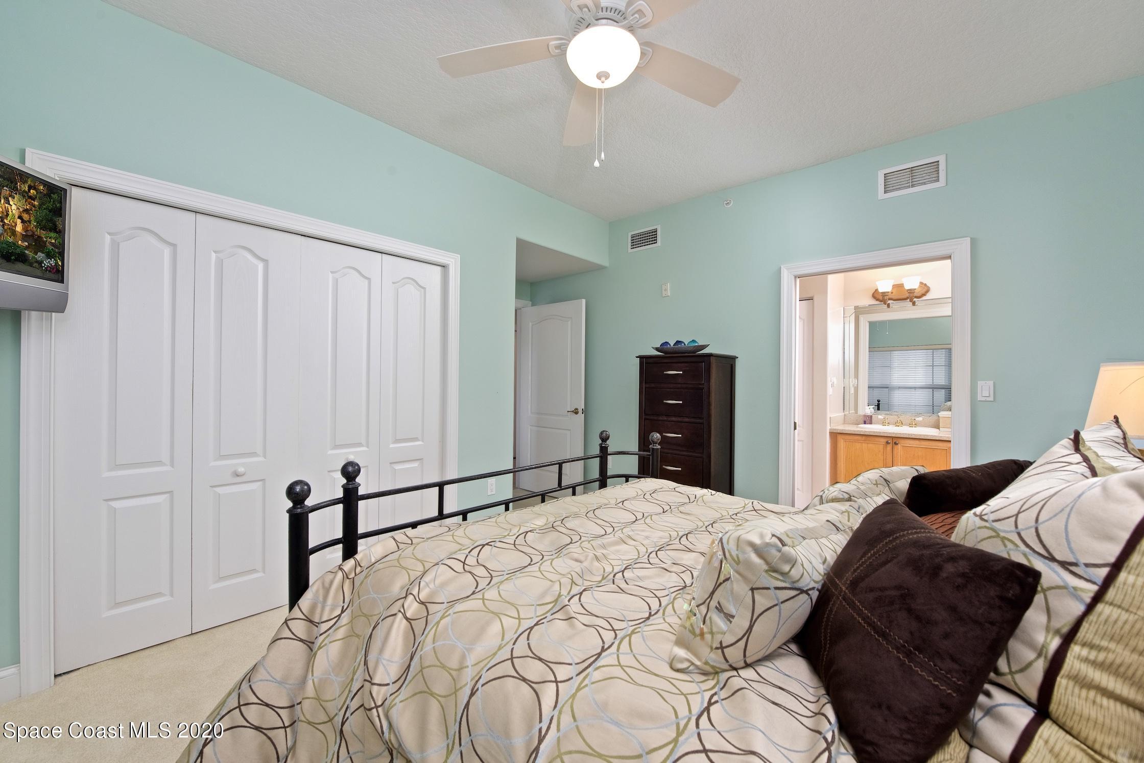 4955 Dixie Highway Northeast, Unit 404 Palm Bay, FL 32905 - Photo 23 of 50 a bedroom with a large bed and a chandelier