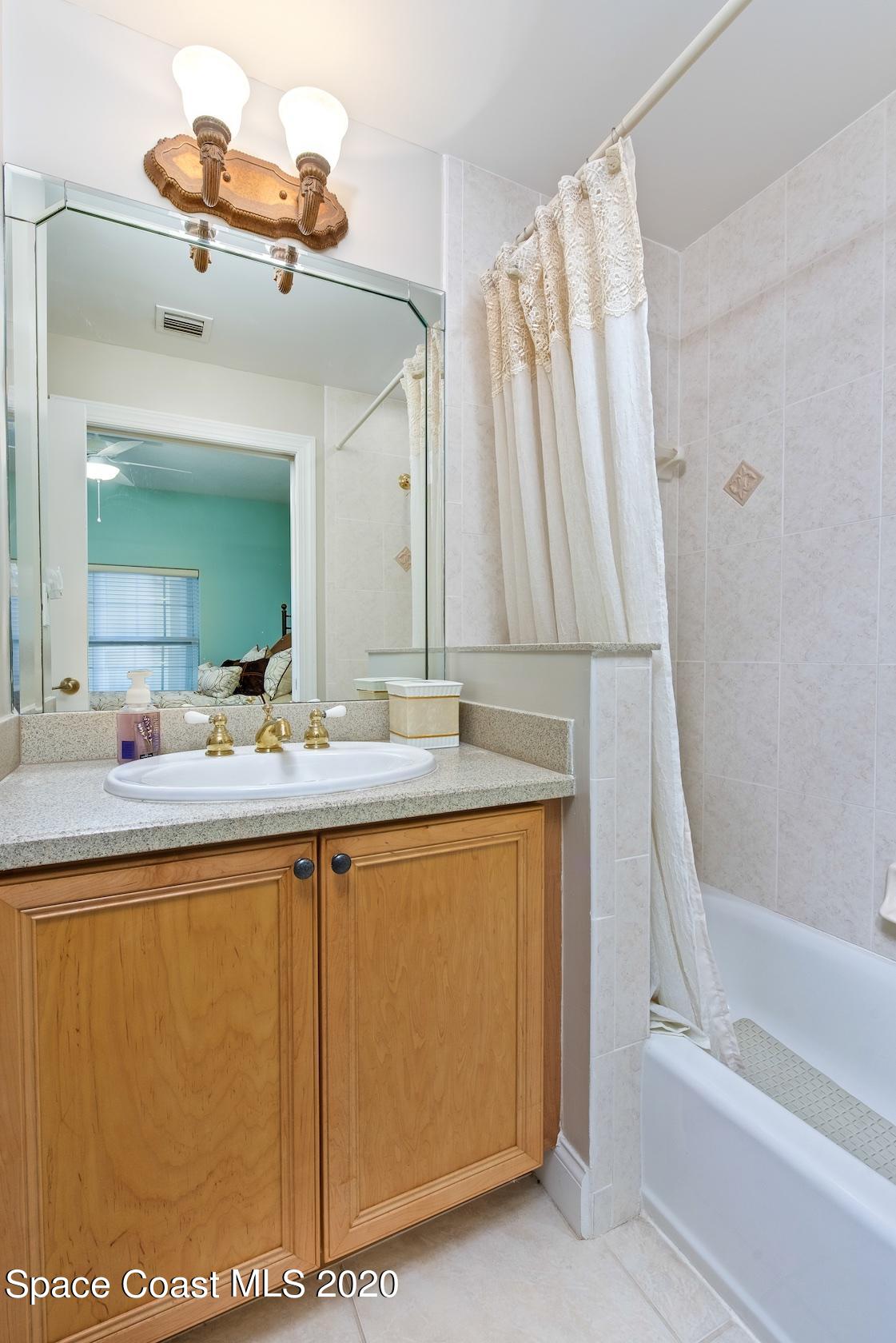 4955 Dixie Highway Northeast, Unit 404 Palm Bay, FL 32905 - Photo 25 of 50 a bathroom with a sink a mirror and a bathtub with a large mirror