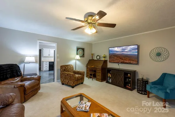 a living room with furniture a window and a flat screen tv