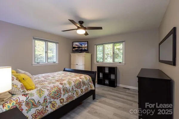 a bedroom with a bed and wooden floor