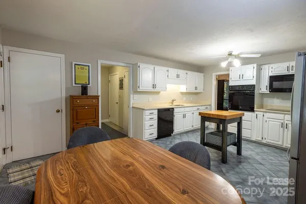a kitchen with stainless steel appliances a stove a refrigerator sink cabinets and wooden floor