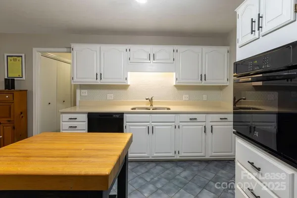 a kitchen with granite countertop a sink stainless steel appliances and cabinets