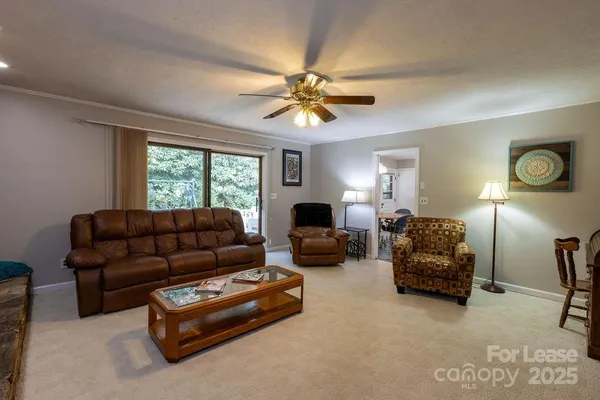 a living room with furniture a ceiling fan and a window