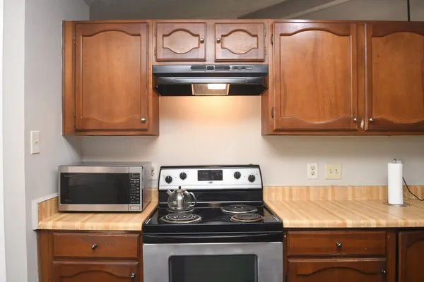 a kitchen with granite countertop wood cabinets and stainless steel appliances